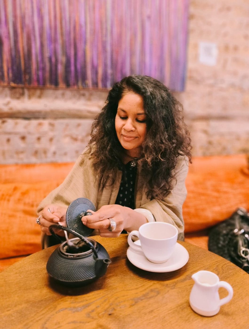 Natasha pouring tea from a cast-iron teapot